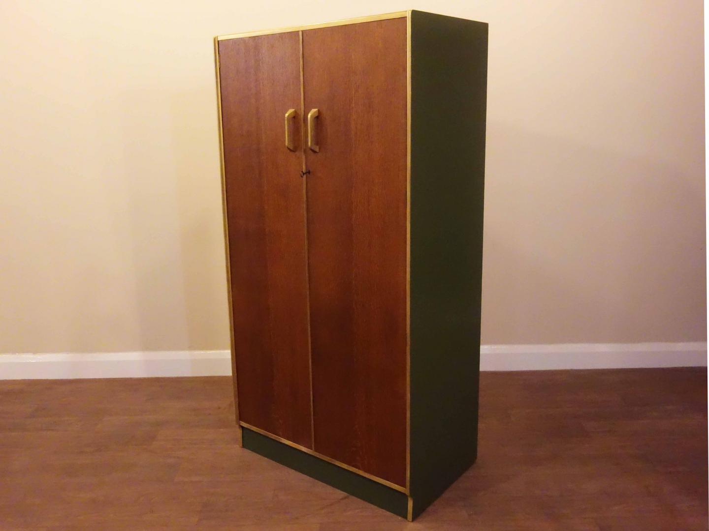 G-Plan 'Brandon' Upcycled Mid Century Double Wardrobe This wardrobe has 2 doors, one hanging rail which goes side to side, and two shelves at the bottom. This piece has been cleaned and painted in our London based workshop, using Little Greene ‘Olive’ paint, gold paint and clear varnish.