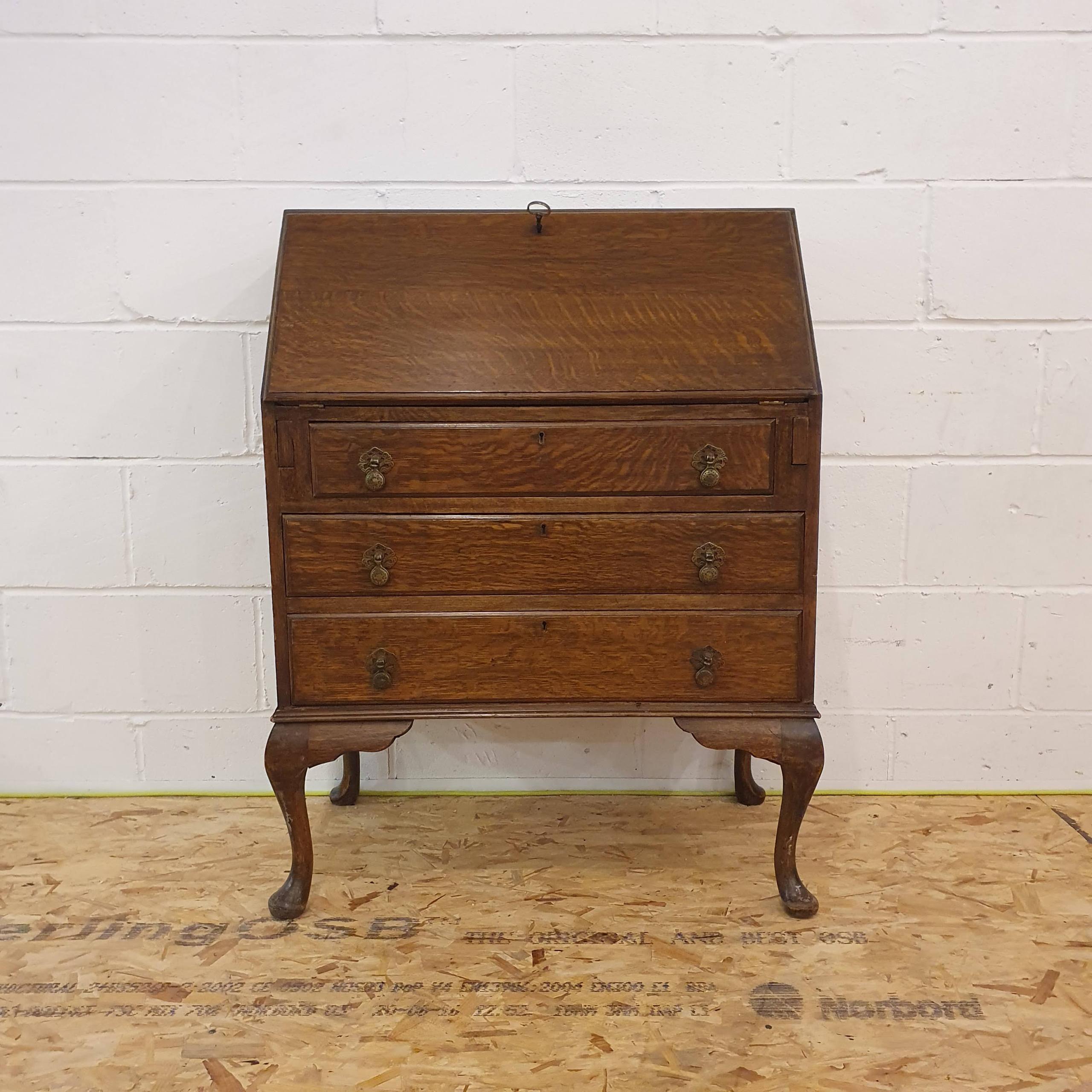 Elegant vintage mahogany bureau desk in classic Queen Anne style, featuring graceful cabriole legs and a polished finish. The drop-down lid opens to reveal a leather-lined writing surface, complete with pigeon holes and a hidden drawer for added character.