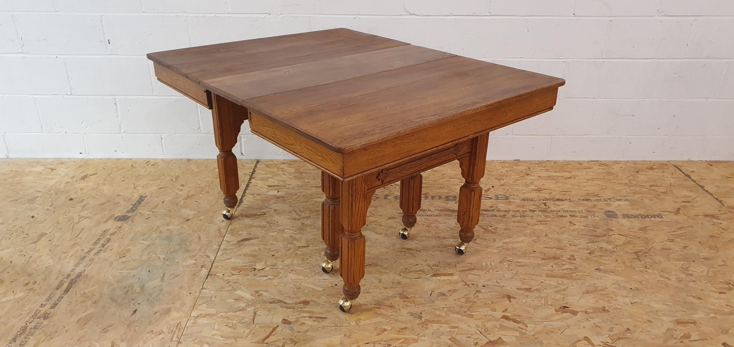 A beautiful, traditional, vintage rectangle extending dining table on spherical castors in an oak colour. Carefully hand-restored, in our workshop.