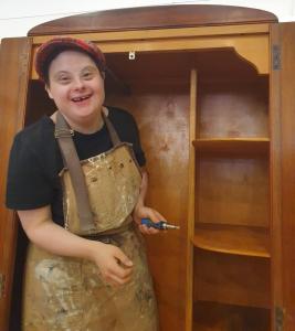 Gemma working on an art deco wardrobe from inside it.