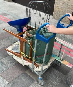 Image shows furniture saved from landfill being moved to the workshop on a trolley