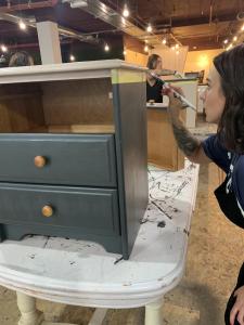Workshop attendees getting to grips with repainting furniture.