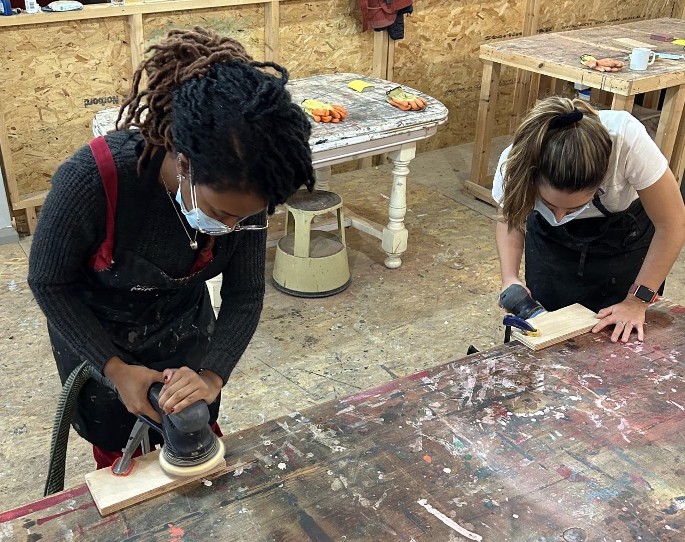 2 people working on hanging coat hooks with sanding machines in workshop diy skills